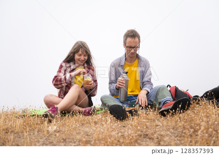 Couple Enjoying a Relaxing Outdoor Picnic on a Misty Day 128357393