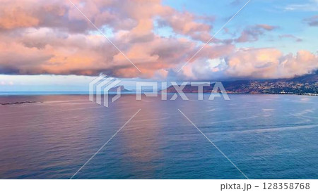 An absolutely breathtaking and stunning view of the vast ocean at sunset, showcasing vibrant clouds and serene waters An absolutely breathtaking and stunning view of the vast ocean at sunset, showcasing vibrant clouds and serene waters 128358768
