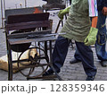 A skilled artisan works at a traditional blacksmith workshop, shaping metal with tools while the forge glows brightly. The setting is filled with handmade creations and tools. 128359346