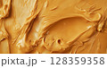 Rich and creamy peanut butter is spread evenly across a textured surface, showcasing its golden color and enticing consistency, perfect for sandwiches, baking, or enjoying straight from the jar. 128359358