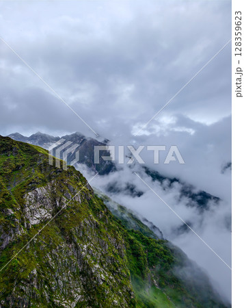 Cloud-Kissed Mountain Valley with Lush Hills 128359623