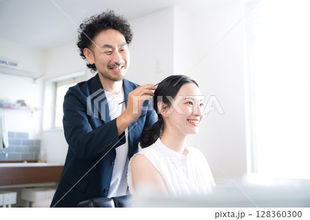 ヘアセットをするヘアメイクの男性と女性　仕上げのイメージ　鏡を見るクローズアップ	 128360300