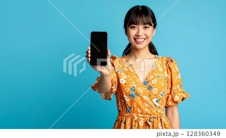 スマホの画面を見せる若い女性 128360349