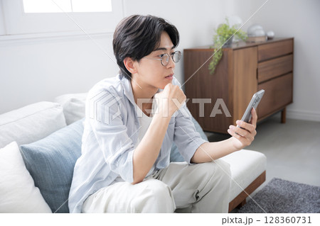 スマホを見る考える男性 128360731