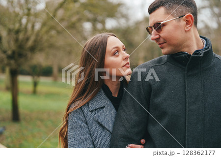 Couple enjoying a peaceful moment in a serene green park during a sunny afternoon 128362177