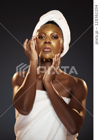 Woman applying gold face mask while relaxing at home in the evening for self-care and beauty treatment Woman applying gold face mask while relaxing at home in the evening for self-care and beauty treatment 128362204