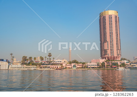 Skyline view of Cairo featuring the Nile River and modern architecture at sunset Skyline view of Cairo featuring the Nile River and modern architecture at sunset 128362263