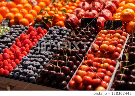 Colorful fruit display at a bustling market showcasing seasonal delights in bright natural light Colorful fruit display at a bustling market showcasing seasonal delights in bright natural light 128362443