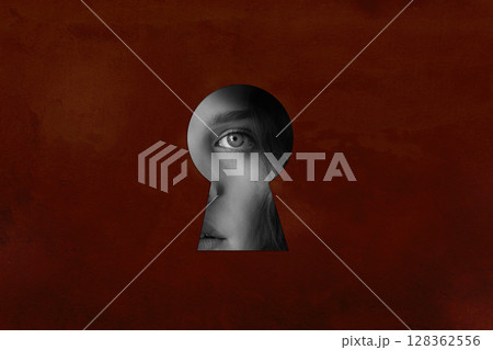 Mystical view through a keyhole revealing a woman's eye and emotion on a textured background 128362556