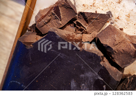 Dark chocolate chunks ready for melting and baking in a kitchen setting during the day Dark chocolate chunks ready for melting and baking in a kitchen setting during the day 128362583