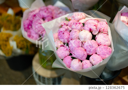 Beautiful peonies in delicate pastel shades arranged for sale at a flower market in the spring season Beautiful peonies in delicate pastel shades arranged for sale at a flower market in the spring season 128362675