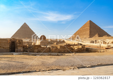 Iconic pyramids of Giza standing tall under a clear blue sky during the day 128362817