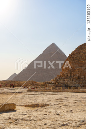 Stunning view of ancient pyramids at Giza under bright blue sky during daytime 128363199