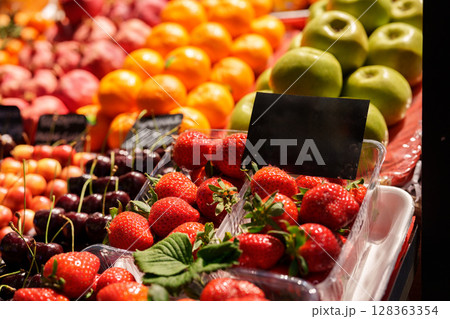 Fresh fruit display featuring strawberries, cherries, oranges, and apples at a vibrant farmers market Fresh fruit display featuring strawberries, cherries, oranges, and apples at a vibrant farmers market 128363354