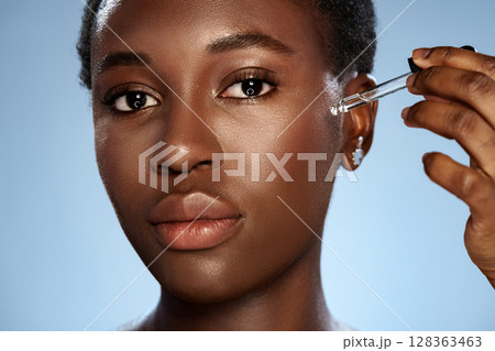 Skincare routine with serum application by a woman in a studio setting Skincare routine with serum application by a woman in a studio setting 128363463
