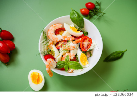 Culinary composition with shrimps, eggs and cheese on a green background Culinary composition with shrimps, eggs and cheese on a green background 128366034