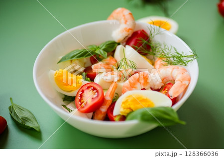 Vegetable salad with seafood and cheese for lunch on a green background 128366036
