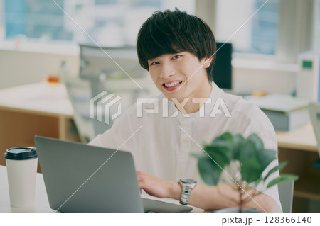 デスクワークする若い男性 128366140