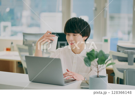 デスクワークする若い男性 128366148