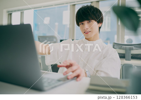 デスクワークする若い男性 128366153
