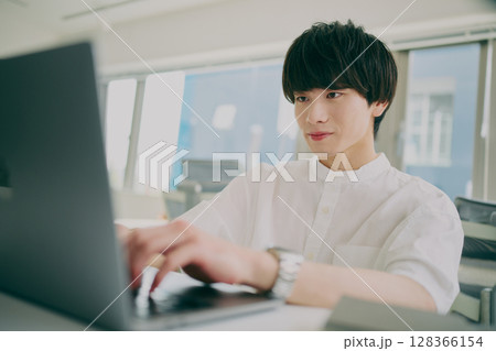 デスクワークする若い男性 128366154