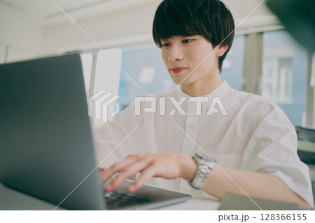 デスクワークする若い男性 128366155