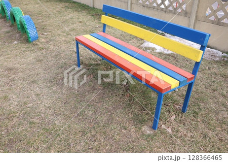 A Colorful Park Bench located in a Vibrant Play Area for Kids and Families to Enjoy A Colorful Park Bench located in a Vibrant Play Area for Kids and Families to Enjoy 128366465