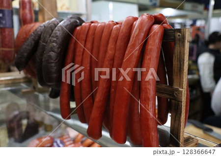 A colorful assortment of assorted sausages beautifully displayed in a bustling market setting 128366647