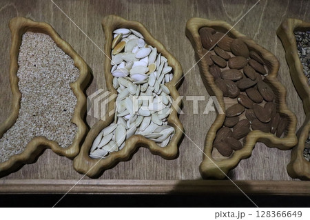 Colorful Seeds and Nuts Arranged in Unique and Artistic Shapes Creating a Stunning Display 128366649