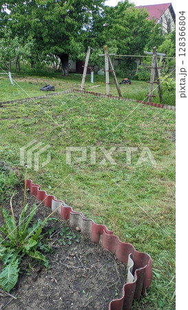 A Serene Garden Landscape Featuring a Play Area Surrounded by Abundant Greenery and Nature 128366804