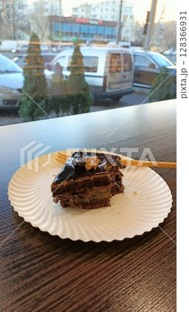 A Delicious Slice of Chocolate Cake Beautifully Presented on a Paper Plate to Enjoy A Delicious Slice of Chocolate Cake Beautifully Presented on a Paper Plate to Enjoy 128366931
