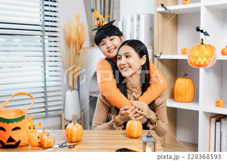Mother and Child Celebrating Halloween with Pumpkins and Decorations in a Cozy Home Setting Mother and Child Celebrating Halloween with Pumpkins and Decorations in a Cozy Home Setting 128368593