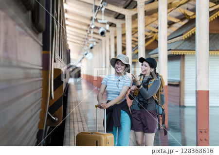 Happy Travelers with Luggage and Backpacks at Train Station Ready for Adventure Happy Travelers with Luggage and Backpacks at Train Station Ready for Adventure 128368616