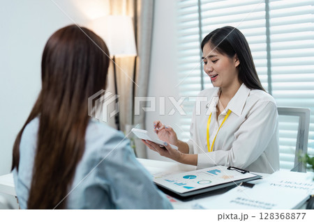Professional Business Meeting with Two Women discussion Financial Report in a Modern Office Setting Professional Business Meeting with Two Women discussion Financial Report in a Modern Office Setting 128368877