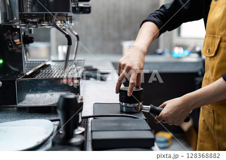Barista Preparing Espresso with Professional Coffee Machine in Modern Cafe Barista Preparing Espresso with Professional Coffee Machine in Modern Cafe 128368882