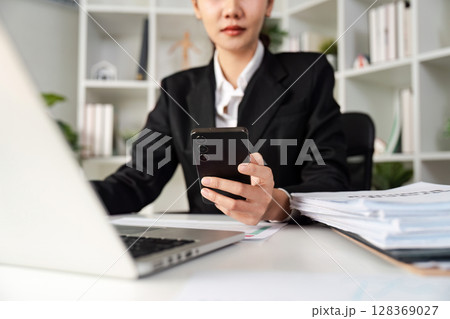 Professional Accountant Working on Financial Report in a Modern Office Setting with Laptop and mobile Professional Accountant Working on Financial Report in a Modern Office Setting with Laptop and mobile 128369027