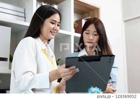 Professional colleagues Business Meeting with Two Women Collaborating in a Modern Office Environment 128369052