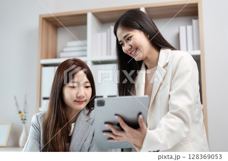Professional colleagues Businesswomen Collaborating on a Digital Tablet in a Modern Office Environment Professional colleagues Businesswomen Collaborating on a Digital Tablet in a Modern Office Environment 128369053