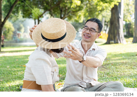Happy Senior Couple Enjoying Retirement Outdoors in a Park on a Sunny Day Happy Senior Couple Enjoying Retirement Outdoors in a Park on a Sunny Day 128369134