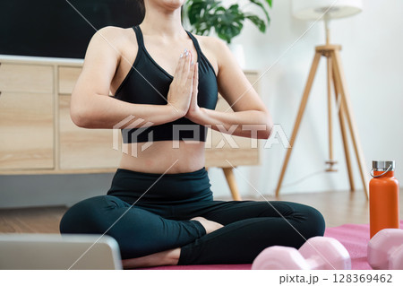 Woman Practicing Yoga at Home for Wellness and Relaxation, Focusing on Mindfulness and Physical Health Woman Practicing Yoga at Home for Wellness and Relaxation, Focusing on Mindfulness and Physical Health 128369462