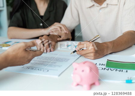 Young Couple Engaged in Financial Planning and Budgeting and signature with Documents and Adviser Financial Young Couple Engaged in Financial Planning and Budgeting and signature with Documents and Adviser Financial 128369488