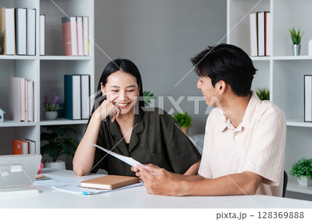 Young Couple Discussing Investment Plans with Financial Planner in Modern Office Setting Young Couple Discussing Investment Plans with Financial Planner in Modern Office Setting 128369888
