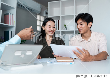 Couple Discussing Investment Plans with Financial Planner in Modern Office Setting 128369916