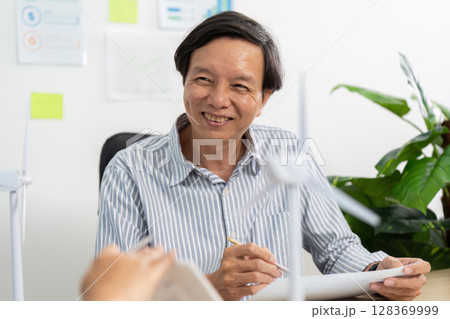 Sustainable Business Discussion. Senior professional engaging in ESG strategy meeting. 128369999