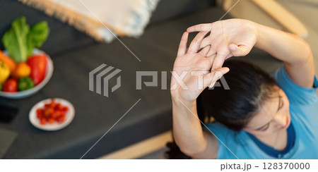 Yoga and Wellness. Woman stretching in home environment with healthy snacks. 128370000
