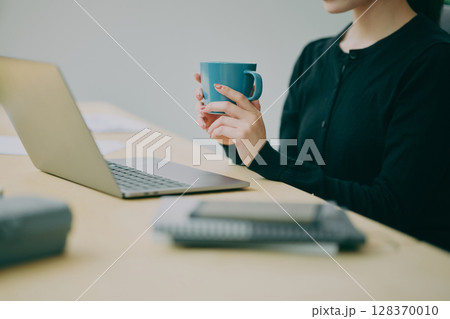 働く人物の手元 128370010