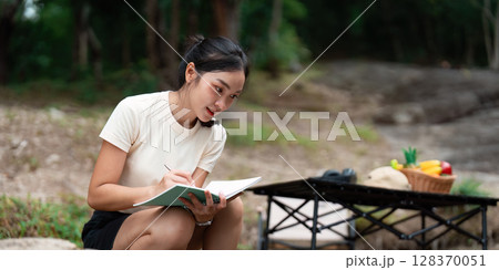 Creative Expression and Nature. Young woman journaling outdoors in a tranquil setting. 128370051