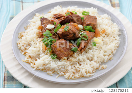 beef slow cooked with gravy served over rice beef slow cooked with gravy served over rice 128370211