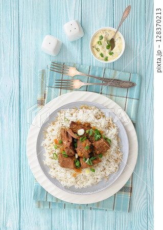 beef slow cooked with gravy served over rice beef slow cooked with gravy served over rice 128370213