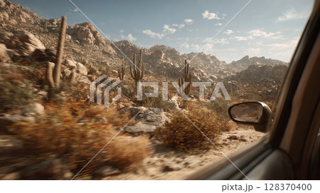 Desert Landscape View from Car Window with Cacti and Rocky Terrain 128370400